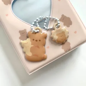 Close-up detail of cute bear double-sided acrylic keychain charm with white beaded chain.