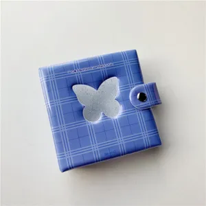 Gedetailleerd overzicht van het blauwe ruitjes mini-fotoalbum met vlindervenster en drukknoop.