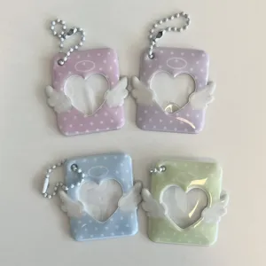 Close up detail of colorful heart shaped angel wing photocard holder and cute bag pendant.