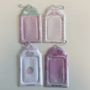 Detail view of cute strawberry and floral PVC photocard holders with ball chains.