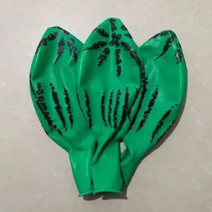 Detailed view of green latex balloons with black watermelon stripe prints, uninflated display.