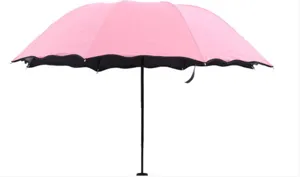 Parapluie de soleil rose portable avec doublure noire et bord ondulé pour un usage quotidien.