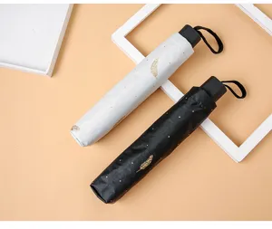 Paraguas plegable portátil con elegante diseño de plumas, protección UV y tela negra.