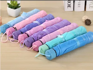 Mini parapluie pliant portable aux teintes pastel douces avec lanière de suspension.