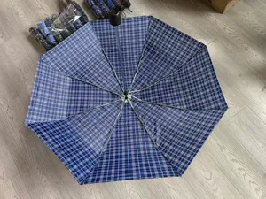 Vista dettagliata di un ombrello pieghevole a quadri blu portatile con robuste stecche.