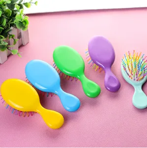 Vue détaillée de mini brosse à cheveux colorée, peigne coussin air portable en plastique.