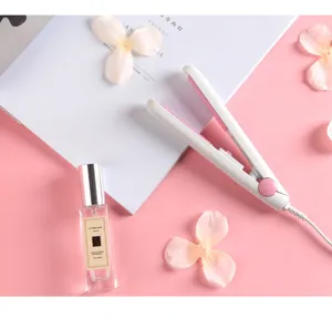 Vista dettagliata del mini piastra per capelli rosa e bianca portatile con decoro floreale.