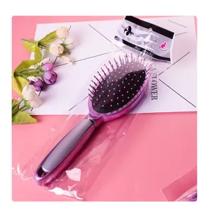 Detail view of the pink cushion hair brush with comfortable massaging pins and ergonomic handle.