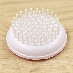 Gros plan sur les poils de la brosse de massage du cuir chevelu, souples et doux.