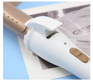 Close-up view of the white and gold hair curling iron showcasing clamp and heating barrel.