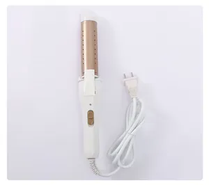 Detail view of a white and gold electric hair curling iron and hair straightener tool with cord.