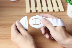 Vue détaillée d'une sangle de sécurité pour enfants blanche montrant le mécanisme de boucle.