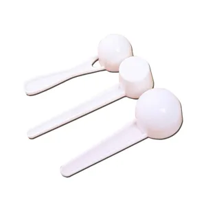 Ensemble de cuillères doseuses en plastique blanc, cuillères à café et lait en poudre.