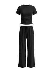 Black two-piece workout set, short sleeve ruched top and wide-leg pants detail.