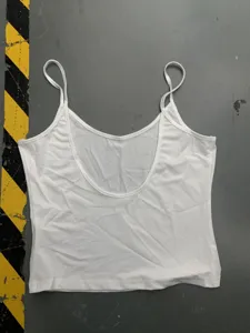 Détail en gros plan d'un simple débardeur blanc uni à fines bretelles et encolure arrondie.