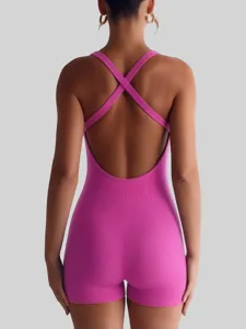 Detailed back view of women's pink ribbed active romper, featuring cross straps and slim fit.