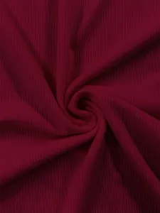 Primo piano dettagliato sul tessuto in maglia a costine rosso scuro, elastico e morbido.