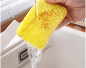 Nahaufnahme des saugfähigen Holzzellstoff-Reinigungsschwamms unter fließendem Wasser.
