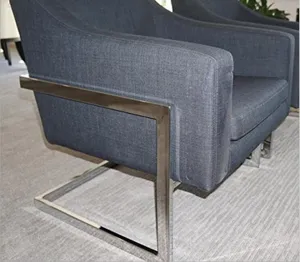 Dettaglio poltrona moderna grigio scuro con struttura in metallo, primo piano arredamento.