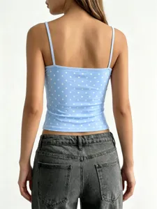 Dettaglio vista posteriore del top corto a pois azzurro abbinato a jeans grigio scuro.