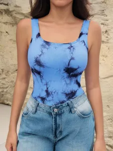 Primo piano dettagliato del body senza maniche a coste con stampa tie-dye blu e jeans denim.