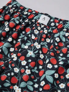 Detailed view of women's casual strawberry print shorts with elastic waist and button detail.