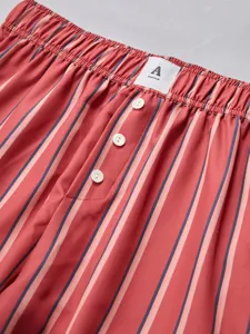 Close-up detail view of striped casual shorts featuring an elastic waistband and button fly.