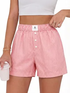 Detail view of women summer pink striped high waist casual boxer shorts with button front.