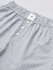 Close-up of women's grey and white striped shorts elastic waistband with buttons detail