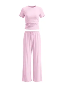 Pink ruched crop top and wide-leg lounge pants detail view showcasing soft ribbed fabric.