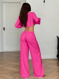 Pink crop top and wide-leg trousers set detail view, showing elegant back silhouette and relaxed fit.