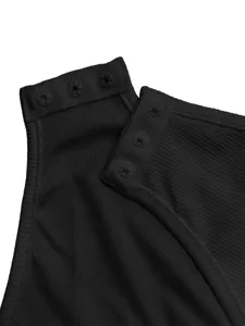 Gros plan détail du col en tissu côtelé noir avec des boutons-pression pour vêtement.
