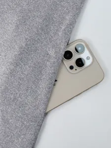 Grey fabric texture detail close-up shot with phone prop, featuring soft and premium material.