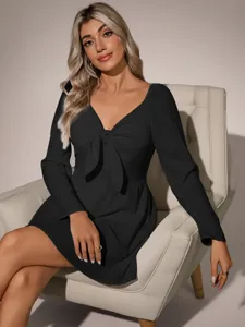 Vista detallada del vestido negro de mujer de manga larga con un lazo en el frente.