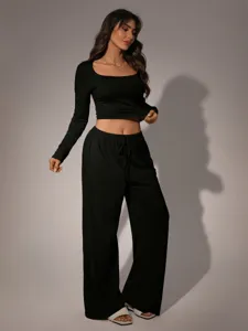 Close-up detail view of black long sleeve crop top and wide leg pants lounge set style.