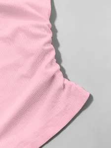 Primo piano dettagliato di un top in maglia a costine rosa con texture e orlo pulito.