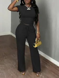 Detail view of women two-piece black ruched short sleeve top and casual sweatpants set.
