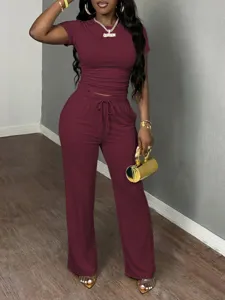 Detailed view of the burgundy short-sleeve top and wide-leg lounge pants set worn by model.