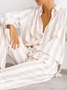 Gros plan sur les détails de l'ensemble de homewear rayé rose et blanc pour femme.