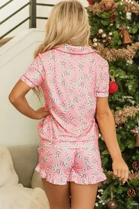 Gedetailleerd overzicht van roze kerst pyjama set met zuurstok print en zachte top.
