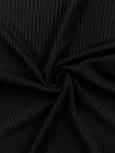 Close-up detail of black ribbed fabric showing texture and stretch for yoga activewear.