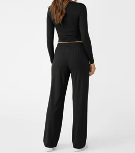 Back view of women casual black long sleeve top and pants detail showing fabric drape.