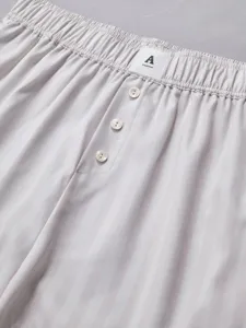 Detailed view of women's casual striped shorts elastic high waist with delicate button accent.