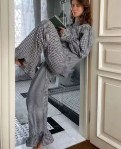 Cozy black and white checkered pajama set with ruffled cuffs for women lounging in style.