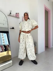Detailed view of the floral print two-piece set featuring a ruffle collar top and balloon pants.