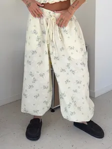 Casual floral two-piece set featuring a cropped top and loose wide-leg drawstring pants for women.