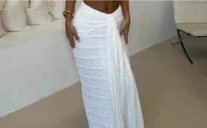 Detailed view of women's white textured maxi skirt featuring elegant front drape and tie design.