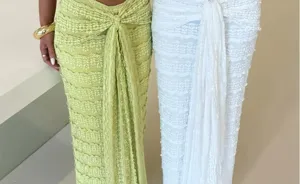Detail view of women's textured long skirt featuring unique pleated fabric and stylish waist tie.