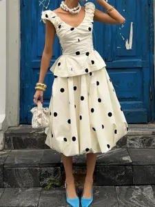 Ensemble chic top peplum et jupemidi bulle à pois avec col en V élégant et superbes volants.