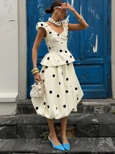 Élégant ensemble à pois avec haut sans manches col en V et jupe midi taille haute pour femmes.
